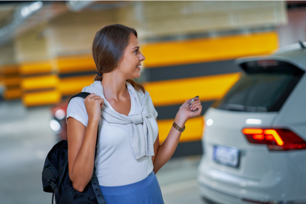 Woman in parking deck clicking door lock on fob