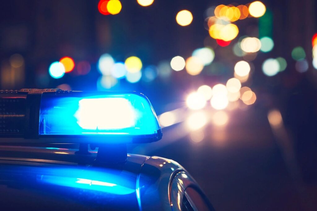 Top of police car on street at night with lights on