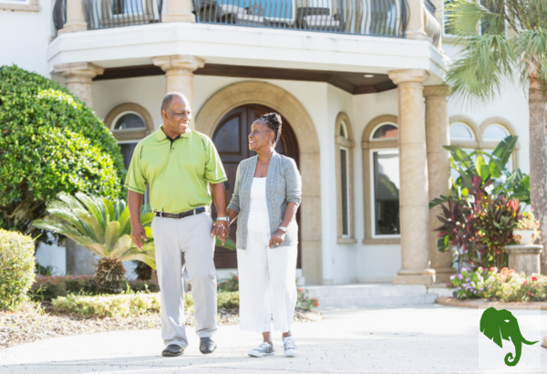 Older couple on a walk in front of house