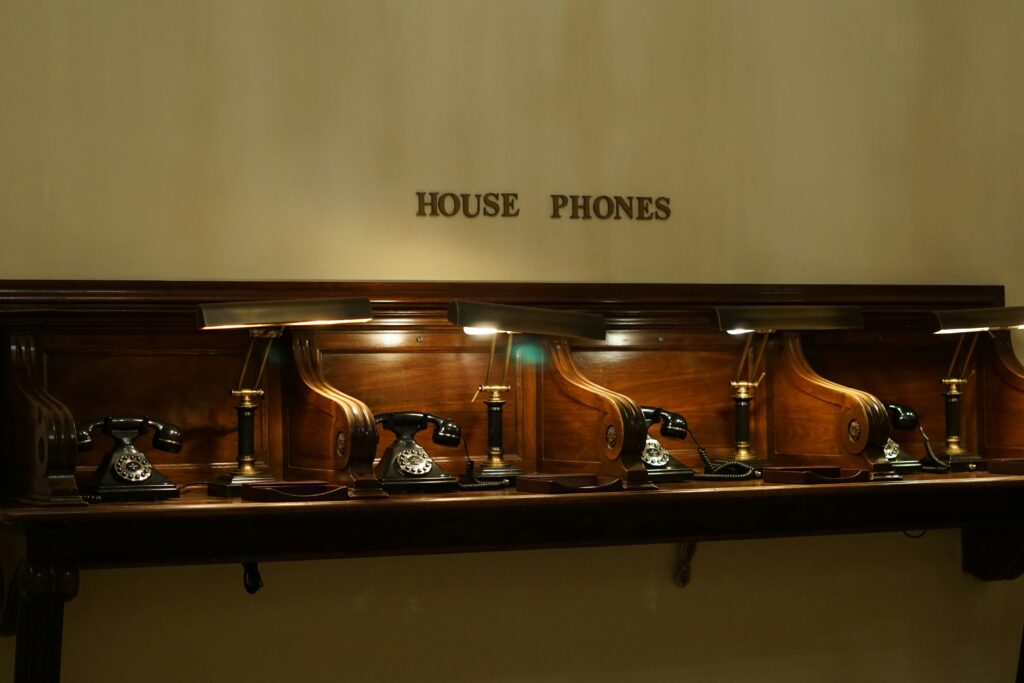 group of old school rotary house phones, likely in a hotel lobby or similar