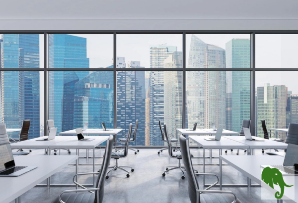 Office with desk and chairs in front of wall-high window