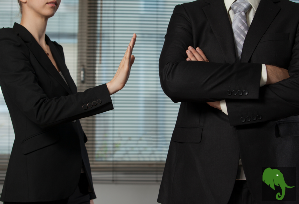 Woman with hand up and extended towards a man standing next to her