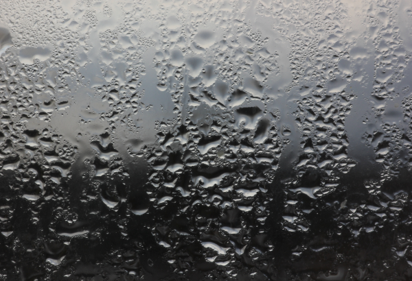 view through vehicle window with dark overcast skies and rain drops on window